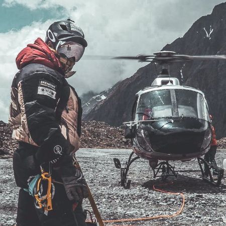 Nirmal Purja MBE posing for a picture infront of a helicopter